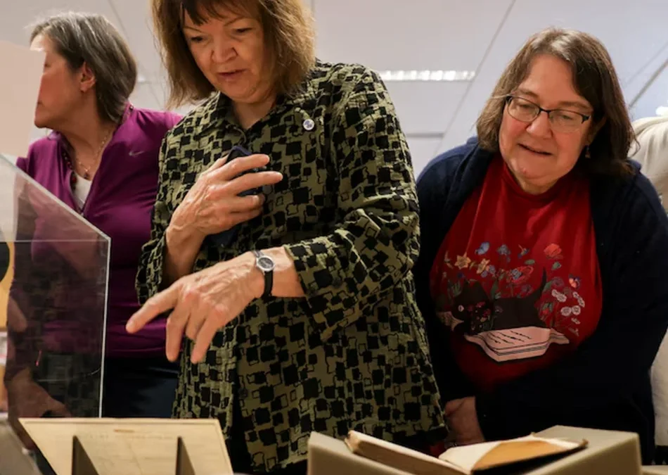 Jane Austen fans hover over a table filled with the Jane Austen Collection documents at Goucher College.