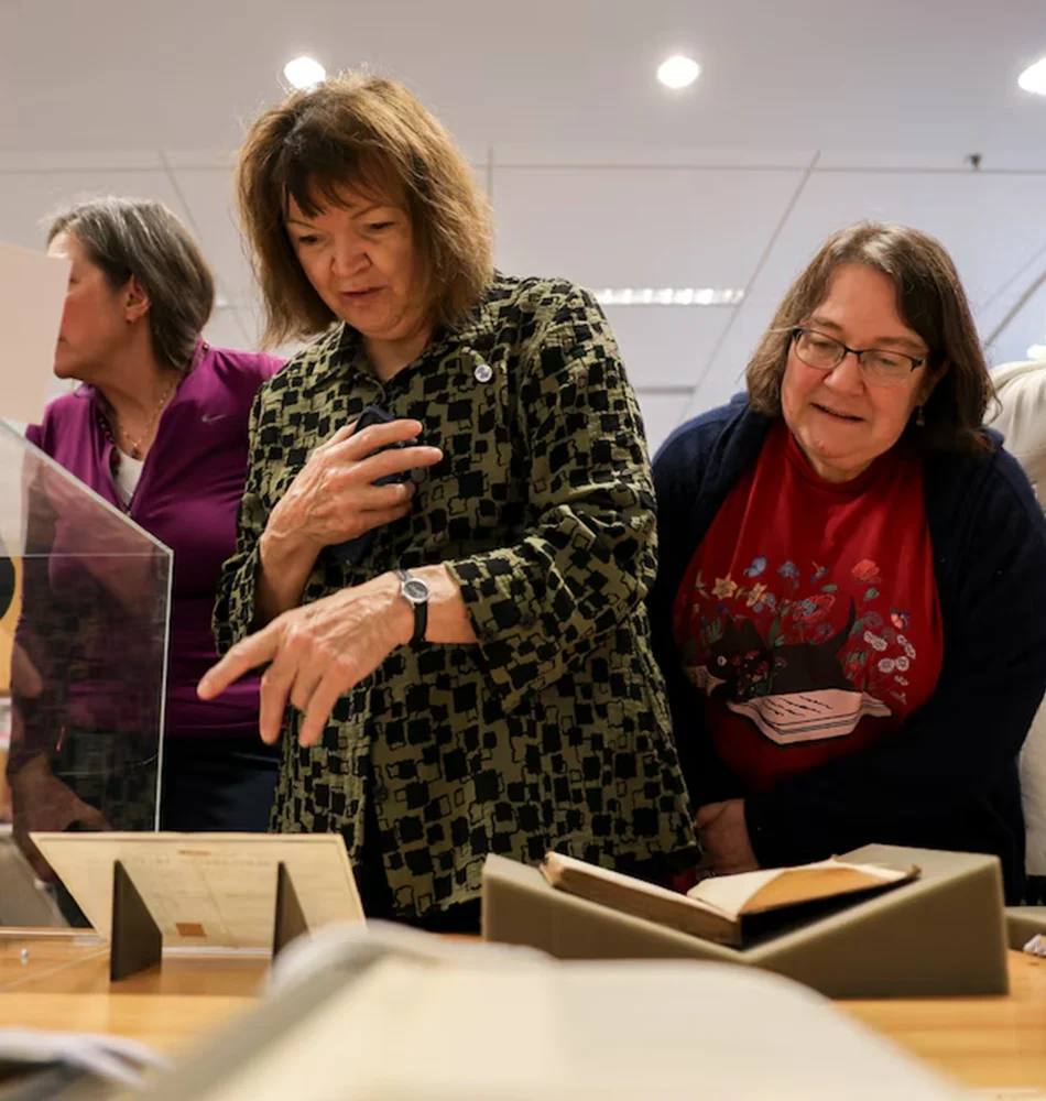 Jane Austen fans hover over a table filled with the Jane Austen Collection documents at Goucher College.